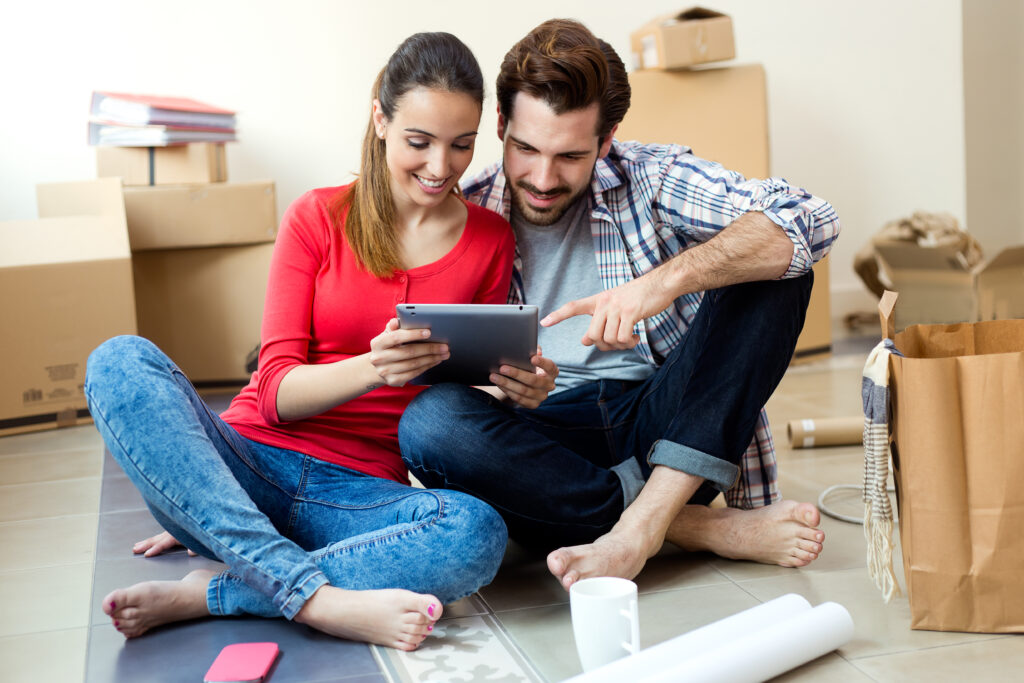 young couple with digital tablet in their new home